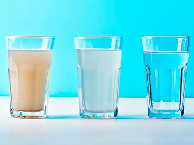 Glasses of water with different clarity, with sediment filter cartridges.